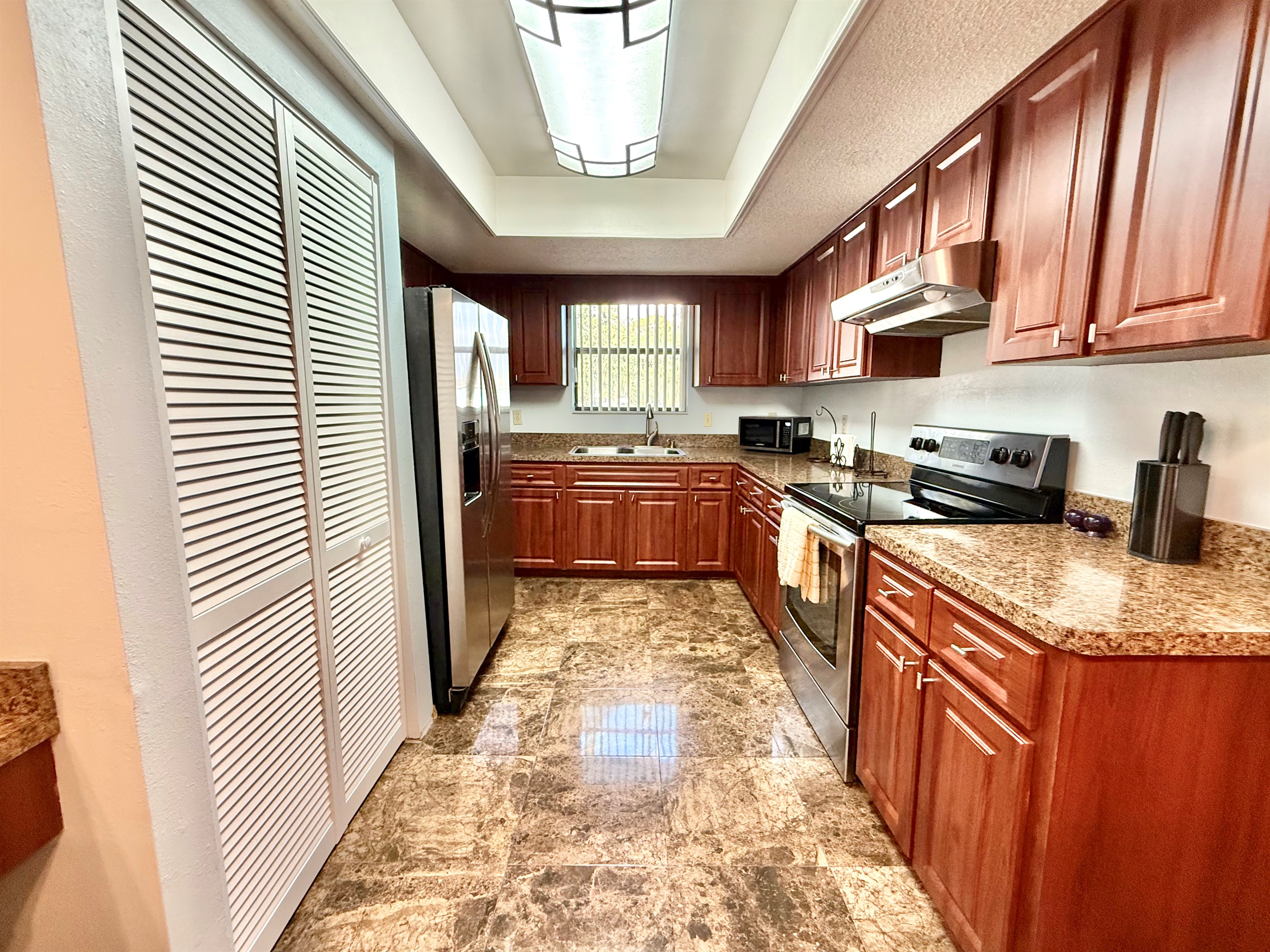 Paired with the rich cabinetry and glossy marble-look tile floors, the space feels both luxurious and functional.