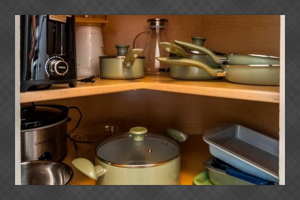 A peek inside the cabinet reveals a full set of cookware, mixing bowls, a toaster, popcorn maker, and crockpot—all ready for your culinary adventures.