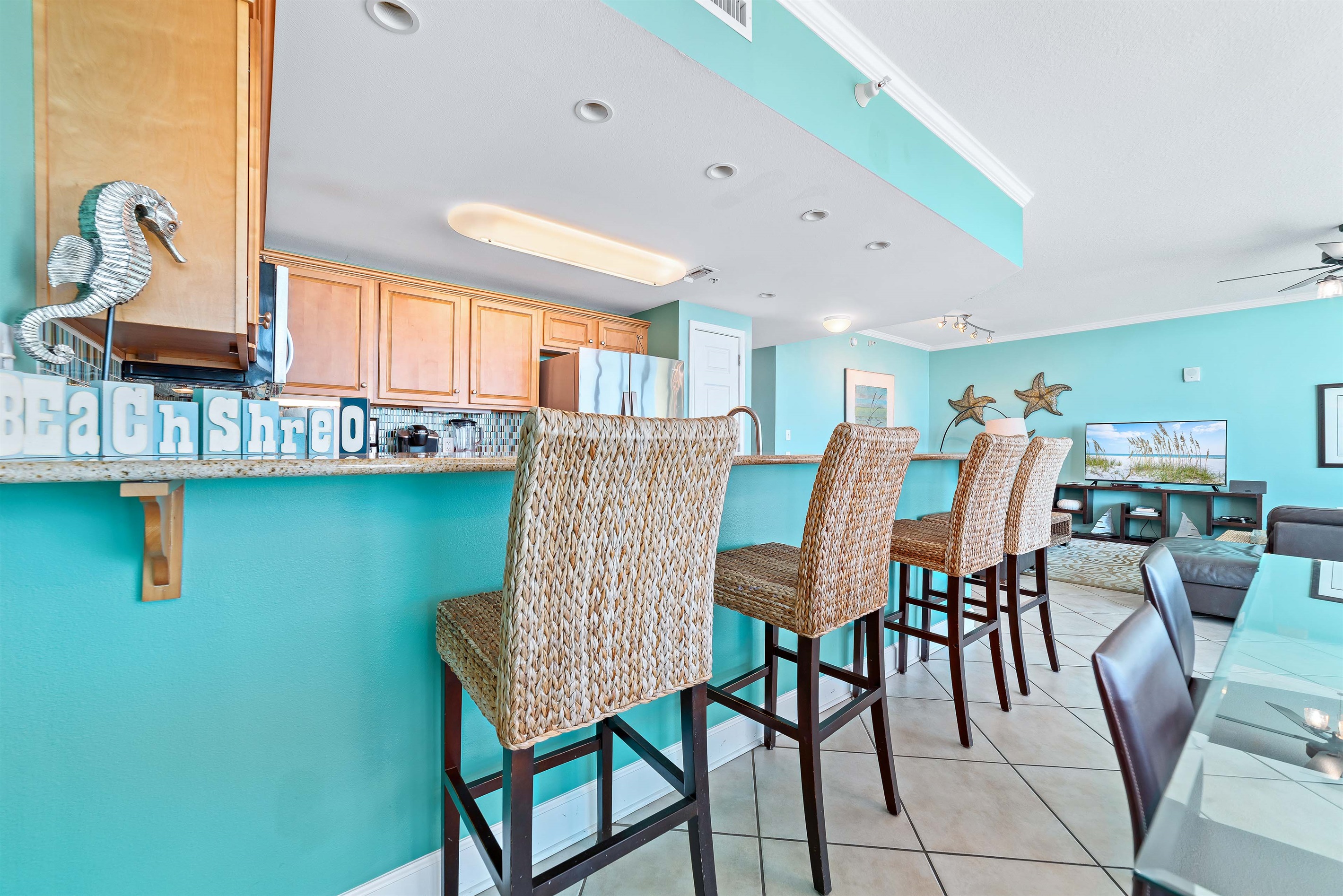 The large island with a breakfast bar provides a central hub for conversation and dining. Whether you're enjoying a quick bite or mingling during a get-together, this area combines comfort and function with style.