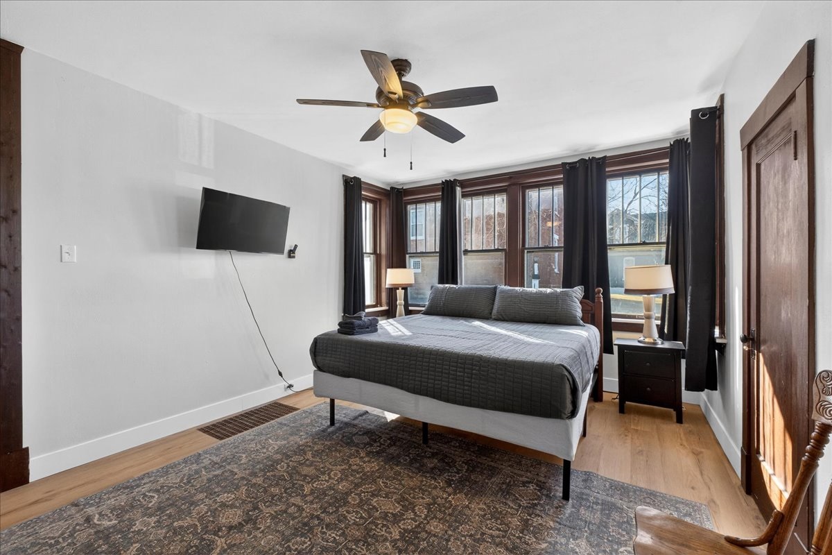 Cozy first-floor bedroom featuring a comfortable king bed, beautifully illuminated with many windows for a relaxing and enjoyable stay!