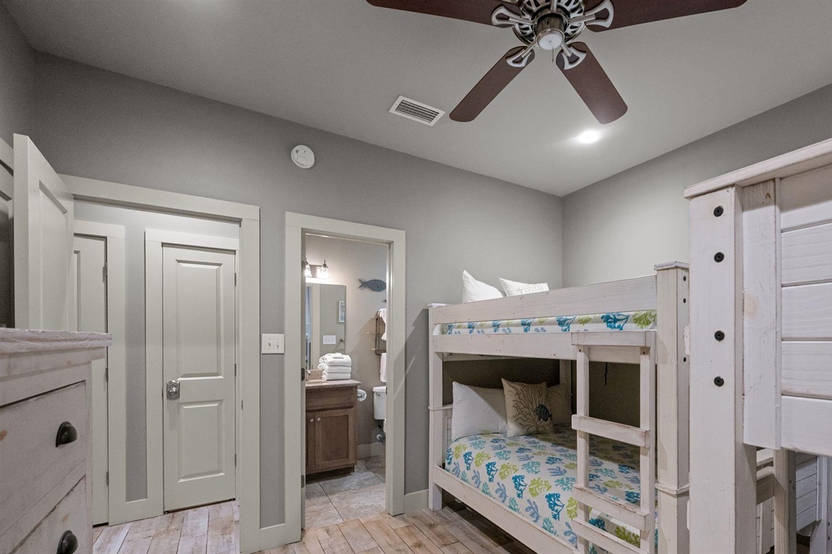 Bedroom with Full over full bunk bed and twin over twin bunk bed  ceiling fan, TV and en-suite bathroom 