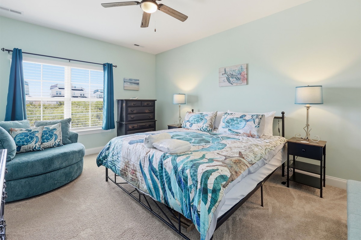 Spacious king bedroom with natural light and coastal touches