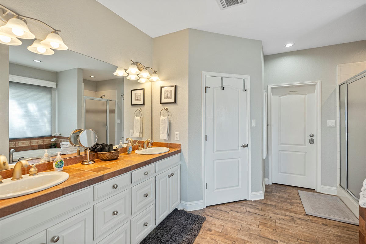 Features a garden tub, stand-up shower, private toilet room, and double vanity sinks.