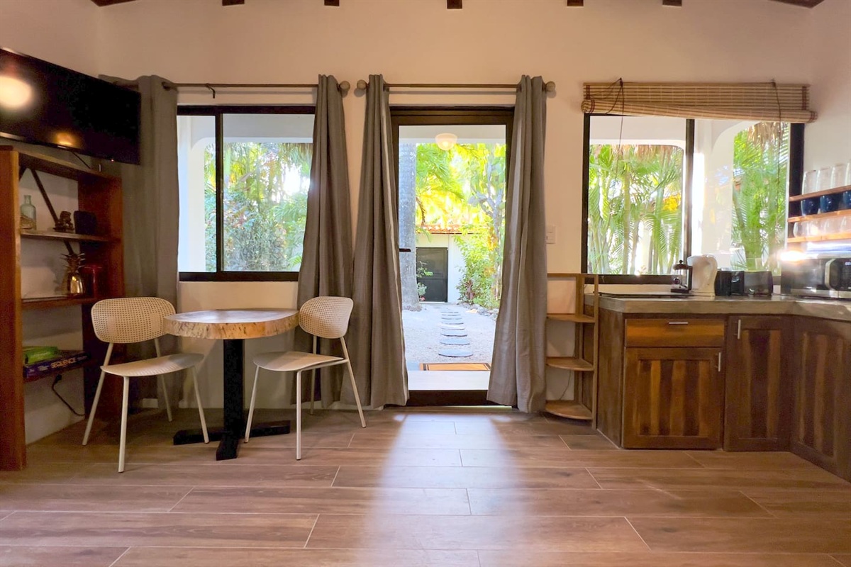 Casa Capri living room looking out on the entrance gate.  Two person dining area on the left and kitchen on the right.  