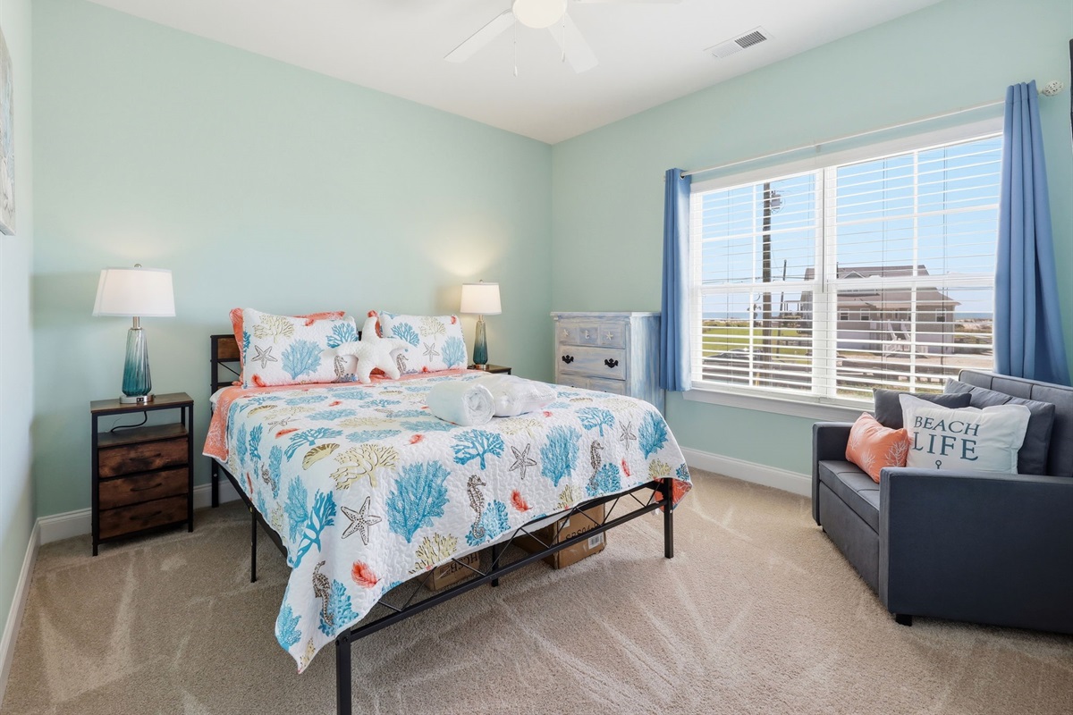 Bright queen bedroom #2 with natural light and a cozy seating corner
