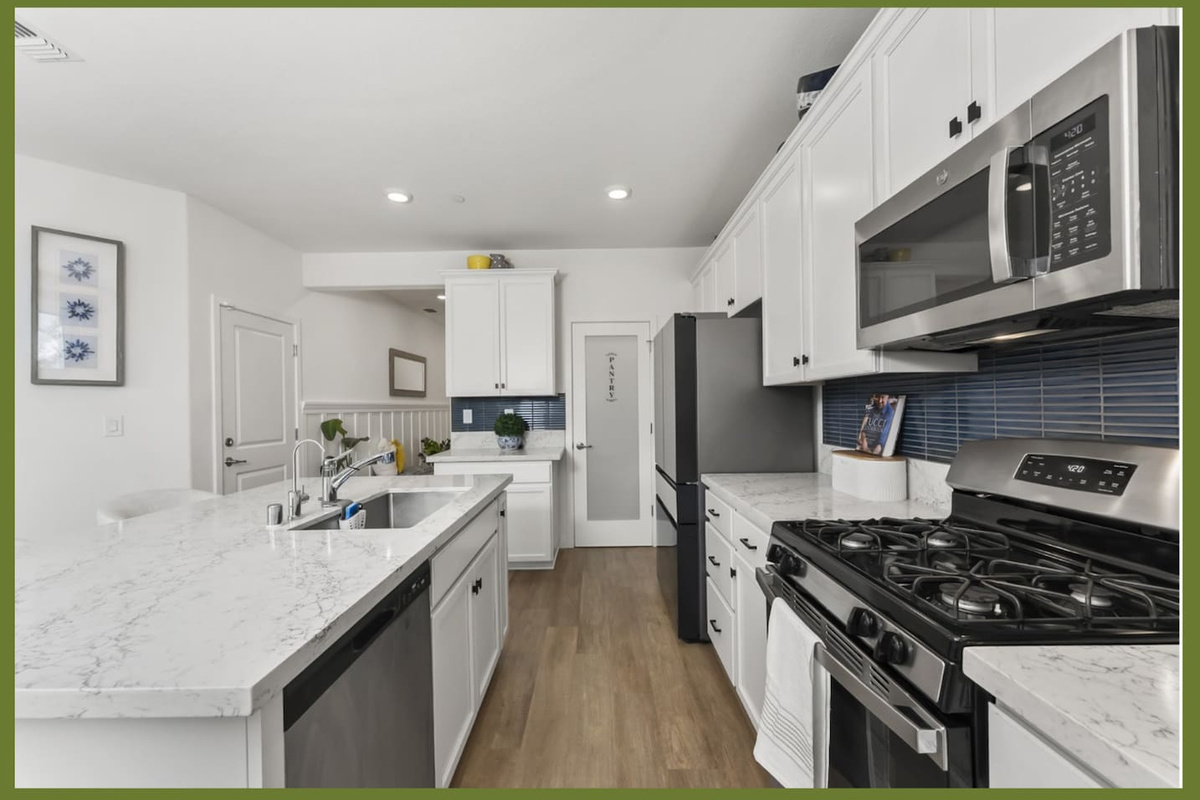 Kitchen with gas stove, stainless steel appliances, marble-style counters, and plenty of prep space for everyday meals.