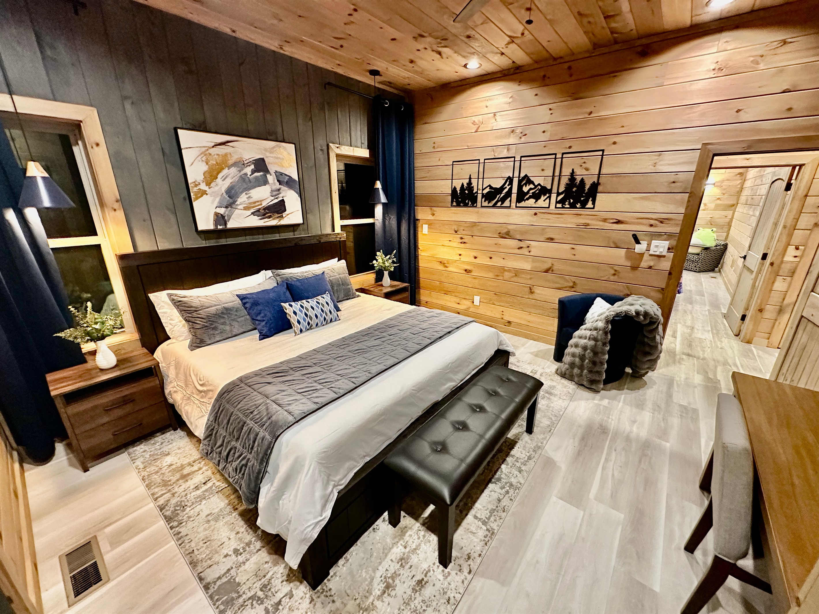 A cozy mountain bedroom with warm wood walls, plush bedding, and calm lighting. Designed for rest and reset, this inviting space is perfect for slow evenings and peaceful mornings after days spent exploring.