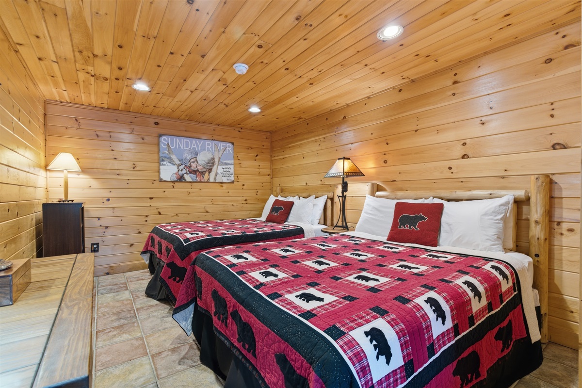 Spacious lower-level bedroom with two queen beds, ideal for groups or kids.