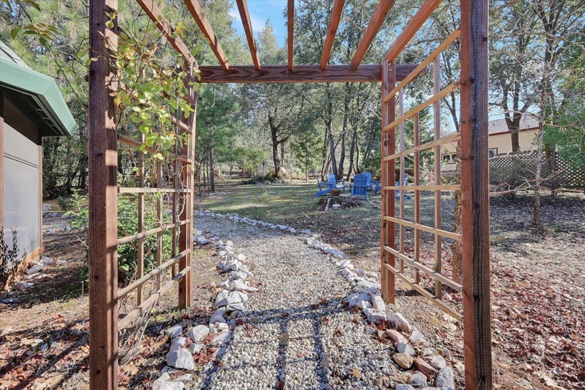Screened porch and wooded side yard with patio seating and a quiet outdoor path.
