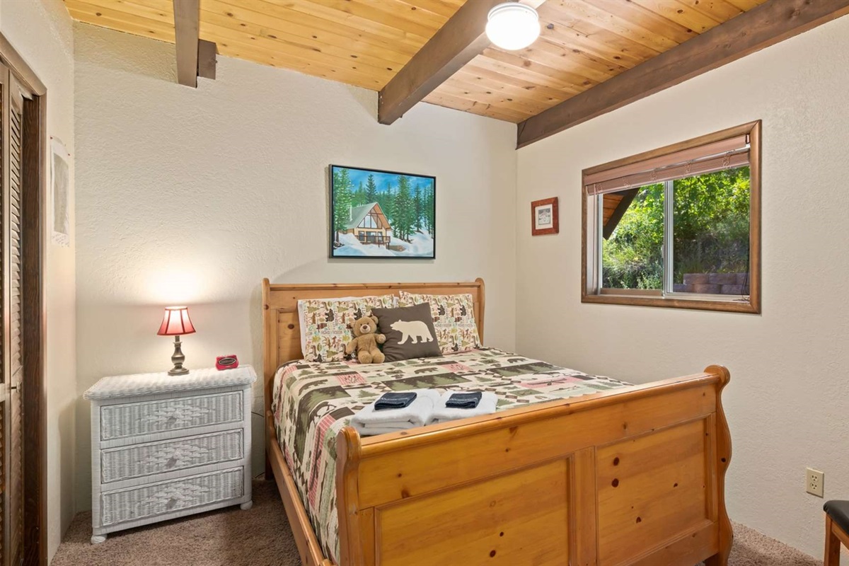 Main floor bedroom with queen bed and cabin charm.