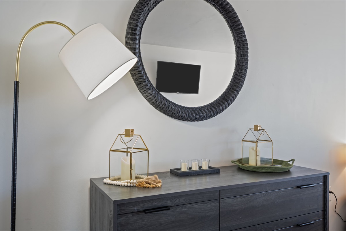Thoughtfully styled dresser with soft lighting, mirror, and coastal-inspired accents