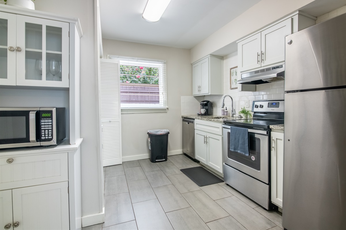 Functional galley kitchen with ample cabinetry, stainless appliances, and essentials for cooking.