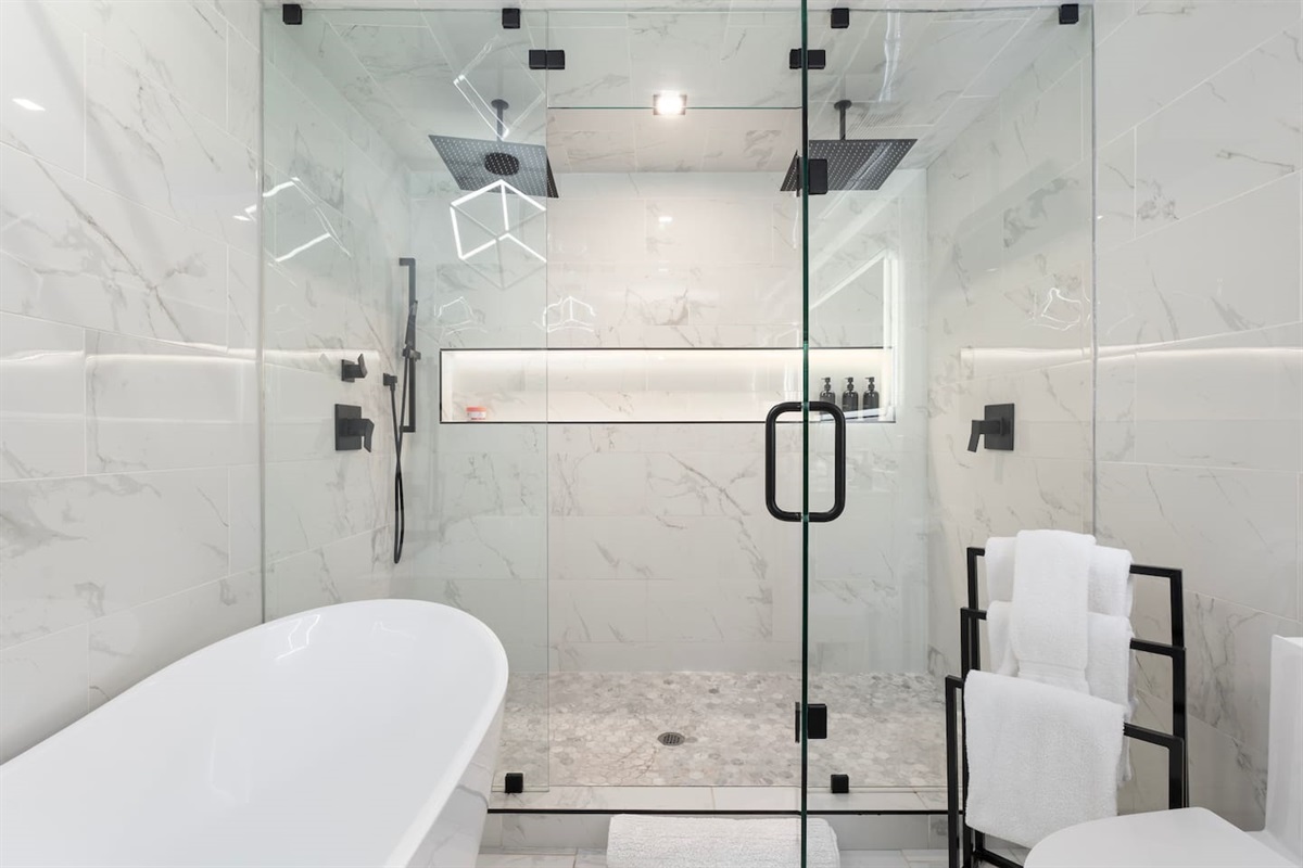 Spacious glass-enclosed shower with dual rain heads and modern design.


