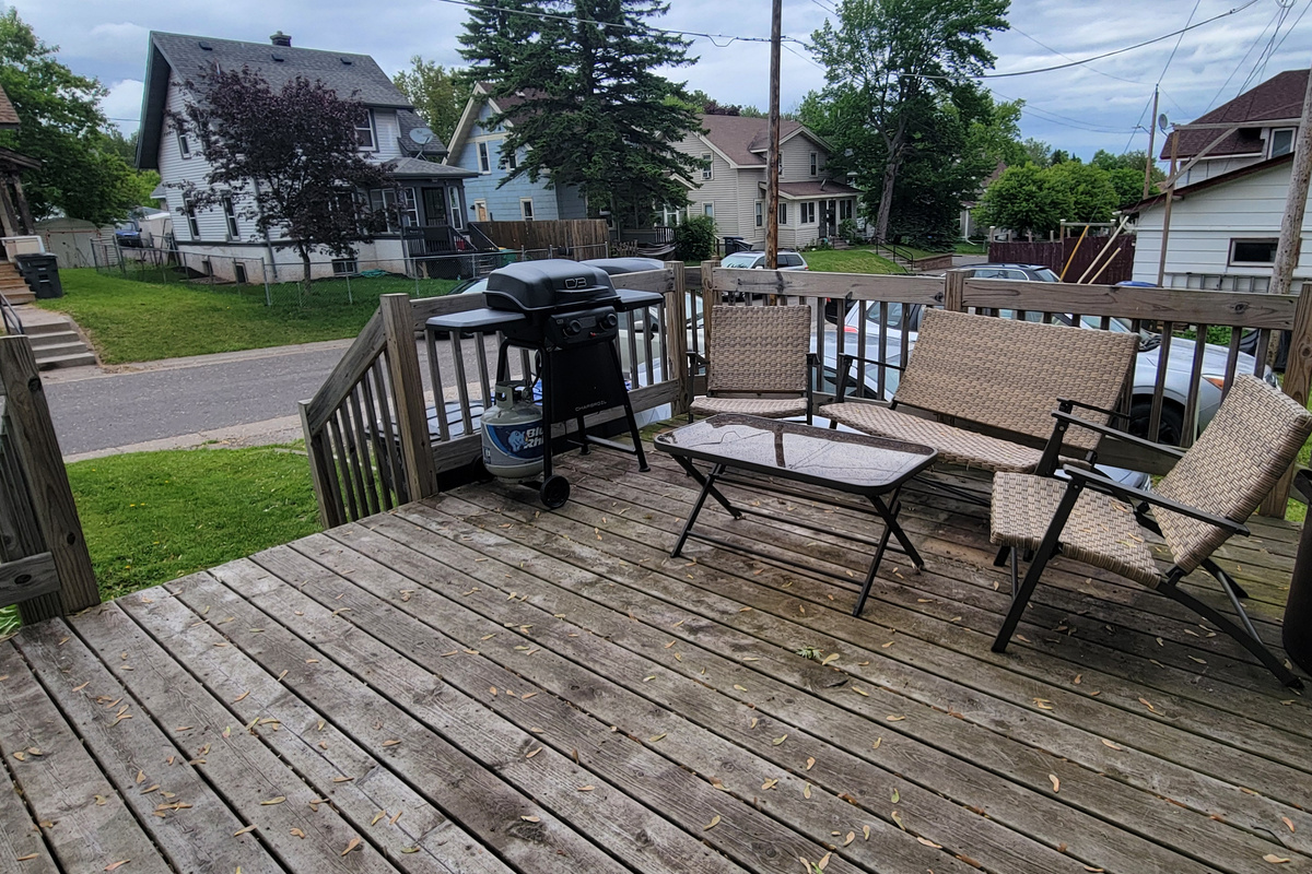 Back deck has seating and a propane grill.