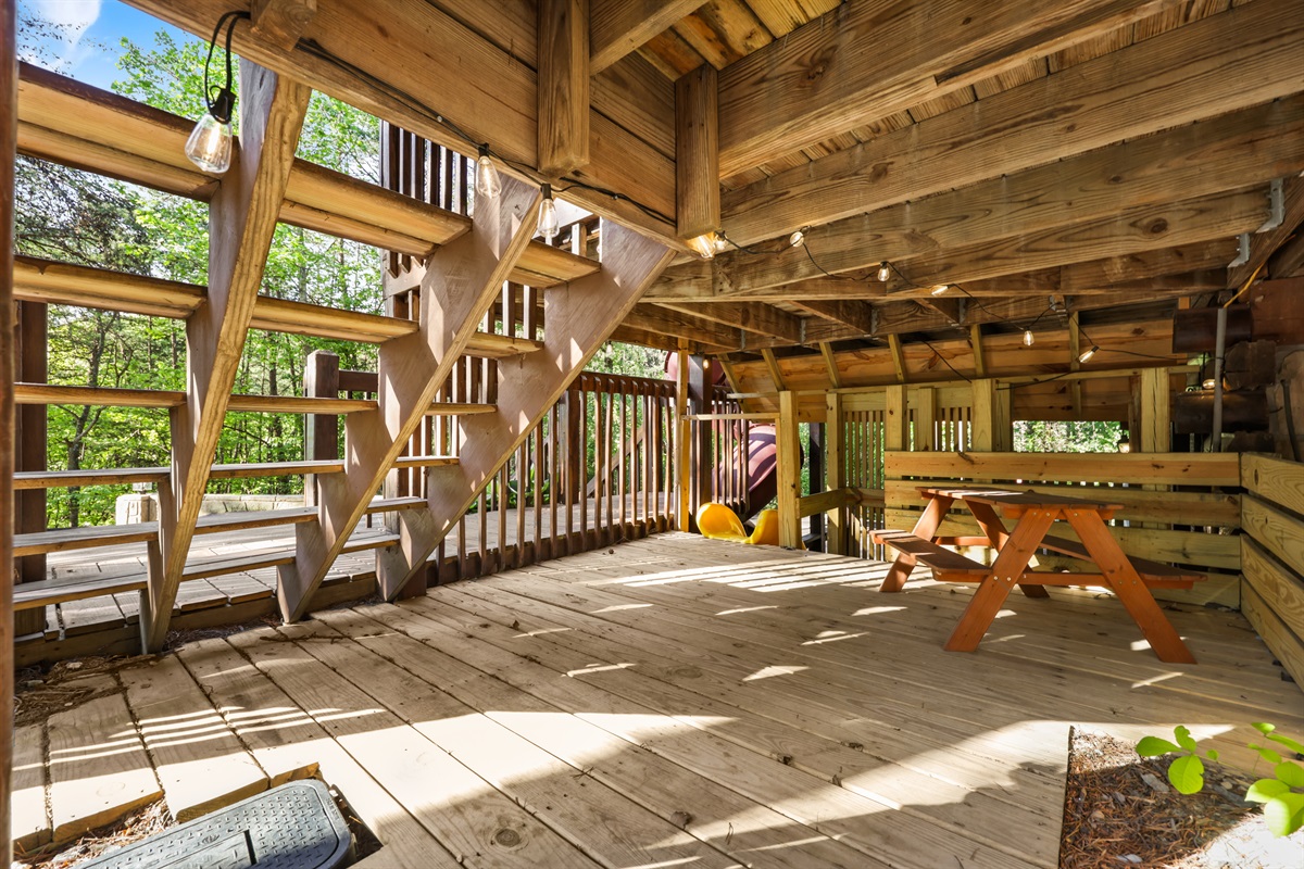 Inside the kids' fort has a picnic table and lighting for them to play