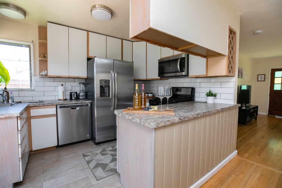 Bright kitchen, large windows, natural light, and high ceilings enhance the ambiance of this one-story Long Beach cottage.