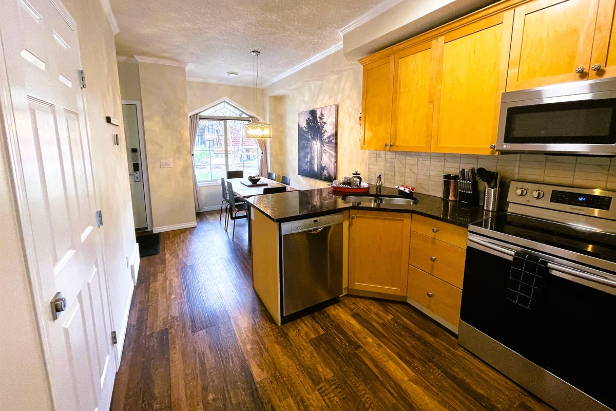 Well equipped walk-through kitchen with granite counter tops, dishwasher, stove and range, microwave, and a large fridge. Coffee maker, tea pot, toaster, blender, and more. Well stocked with pots, pans, dishware, and glassware. Shared BBQ outside.