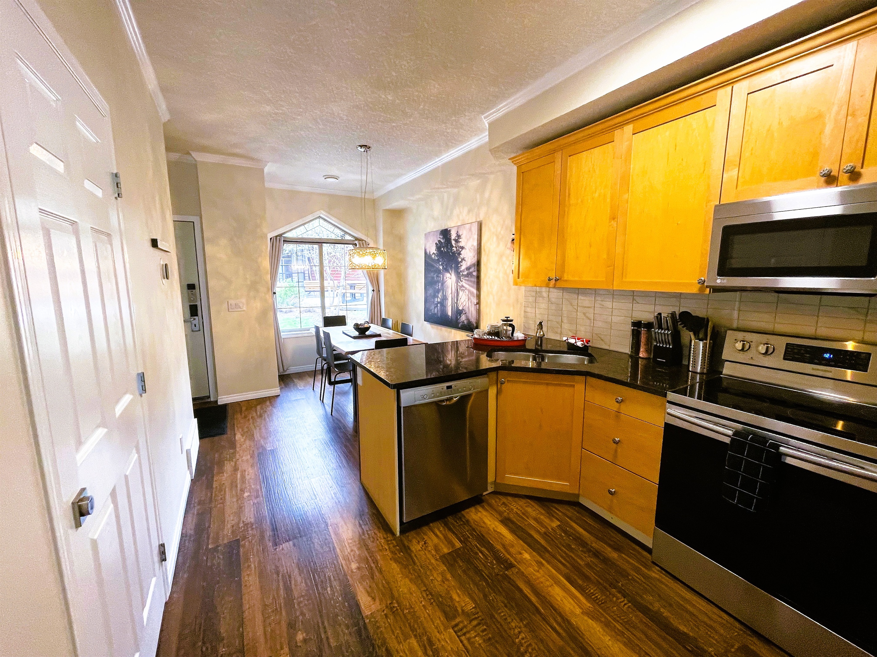 Well equipped walk-through kitchen with granite counter tops, dishwasher, stove and range, microwave, and a large fridge. Coffee maker, tea pot, toaster, blender, and more. Well stocked with pots, pans, dishware, and glassware. Shared BBQ outside.