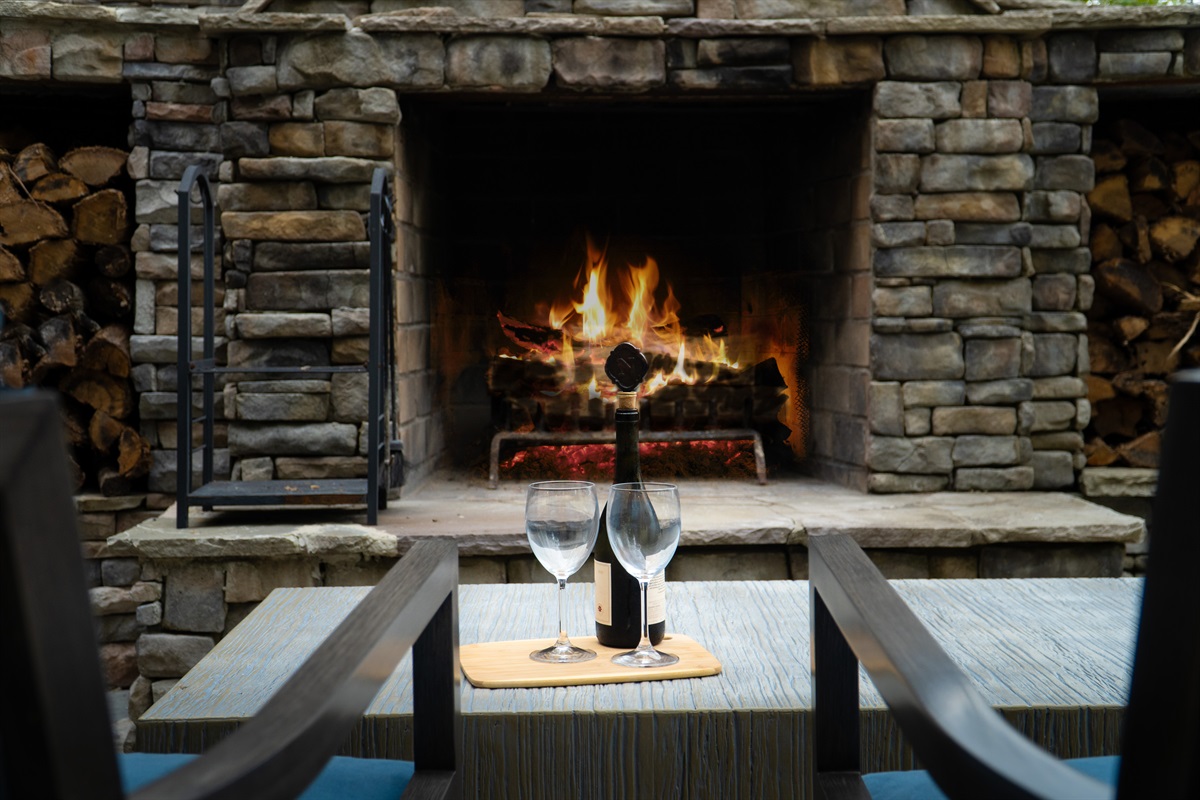 Relax by the outdoor fireplace, an inviting spot to gather, share stories, and take in the peaceful lake views.
