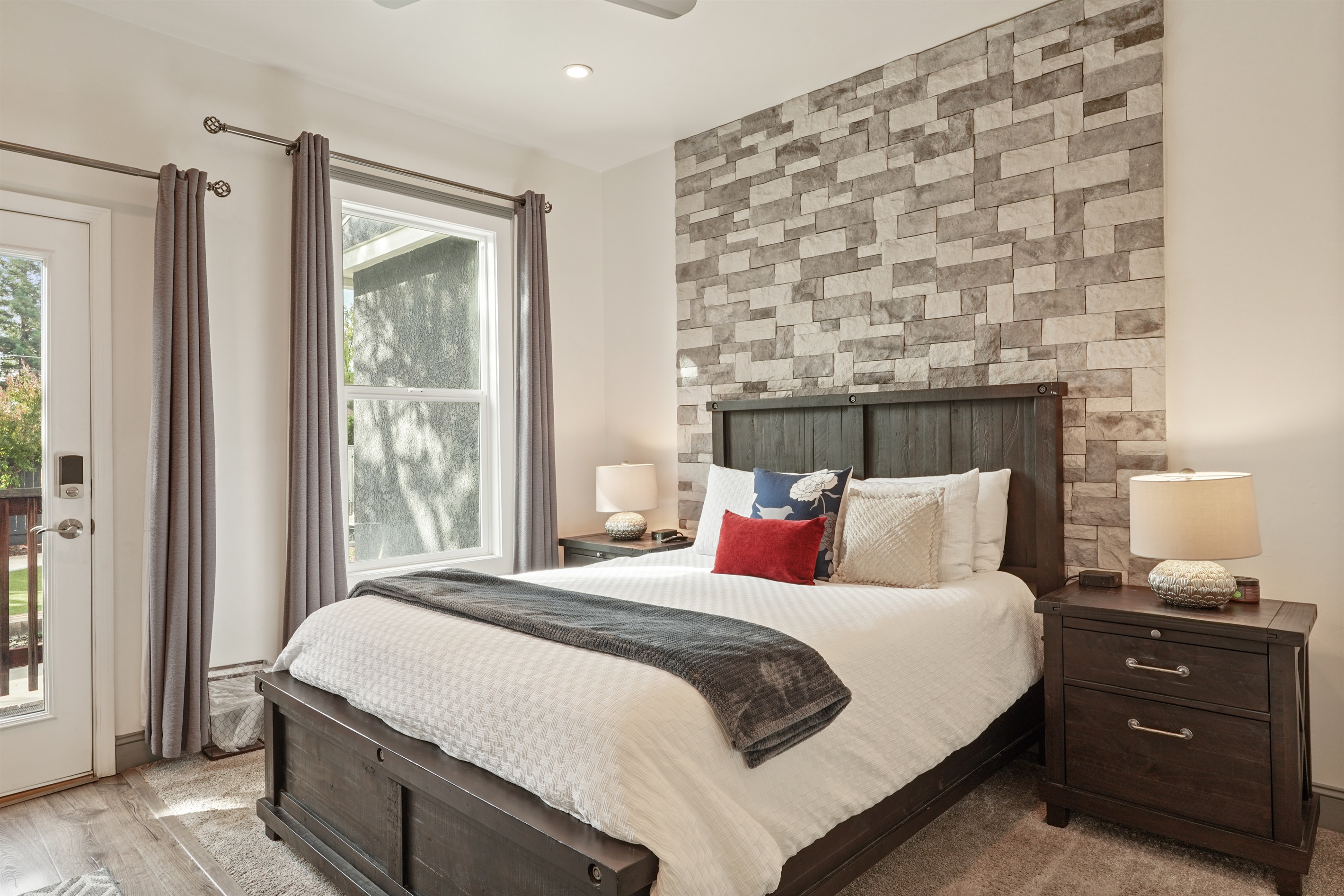 The main bedroom has a queen-sized bed, smart TV, walk-in closet, and direct access to the backyard.