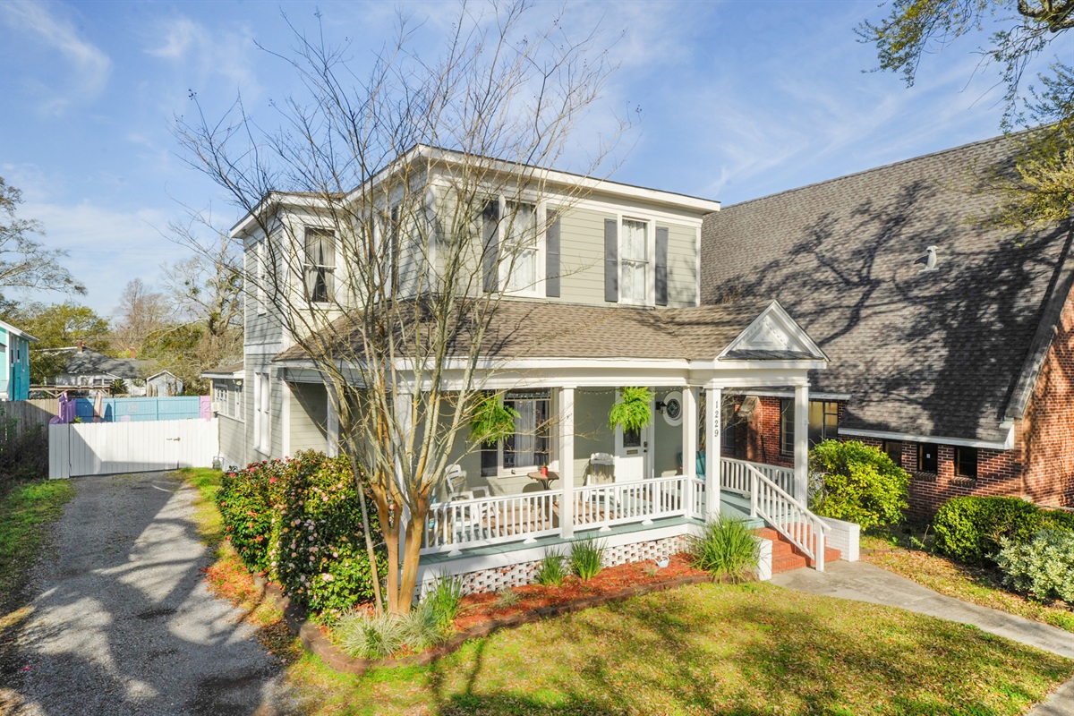 Green front yard, driveway parking, gated and fenced back courtyard with more parking.