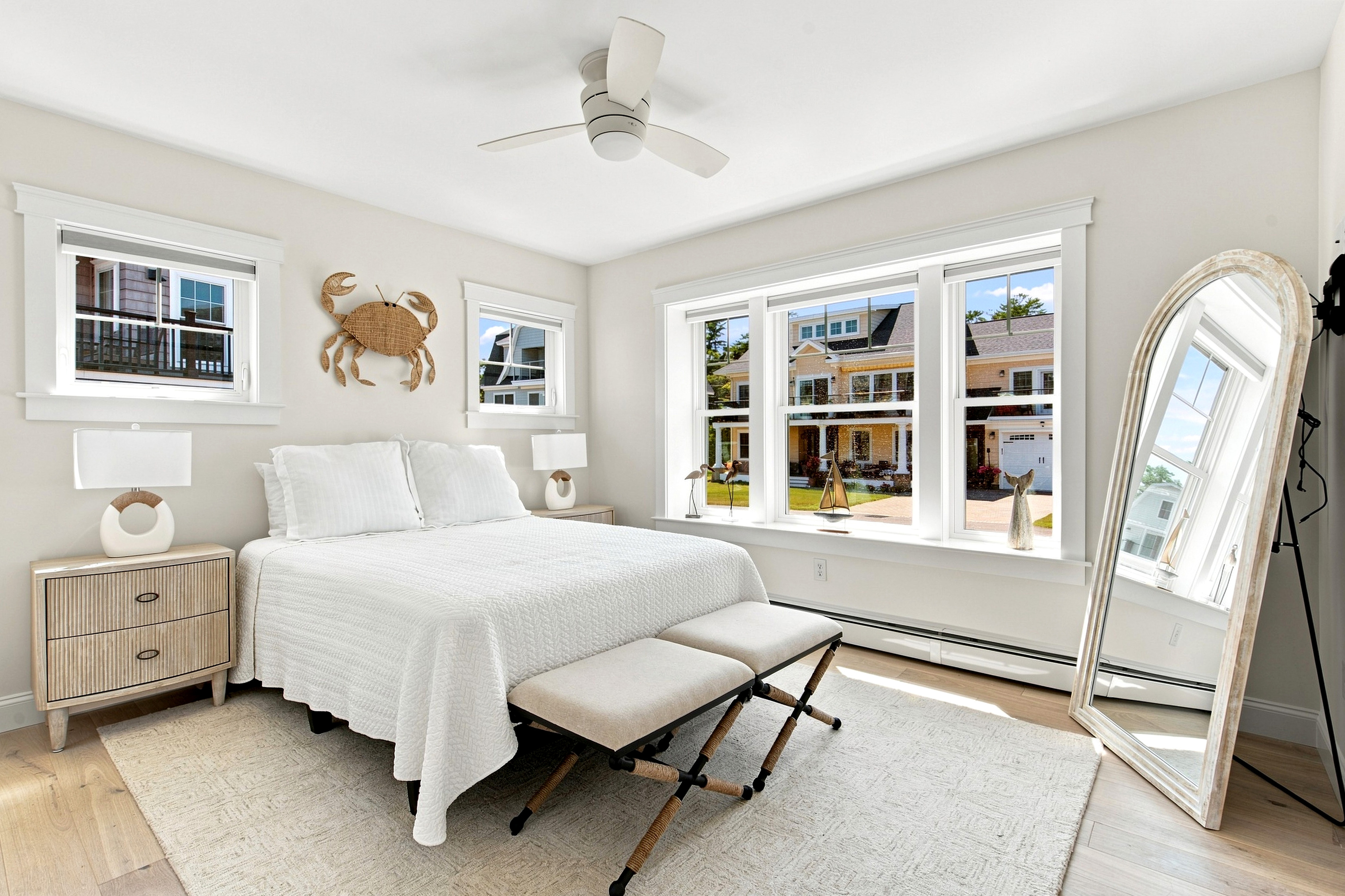 Bright windows and charming coastal touches give this bedroom a relaxed beach-house feel.