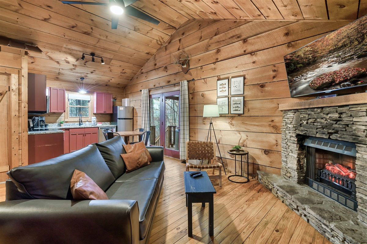 Open kitchen and living room with stone fireplace