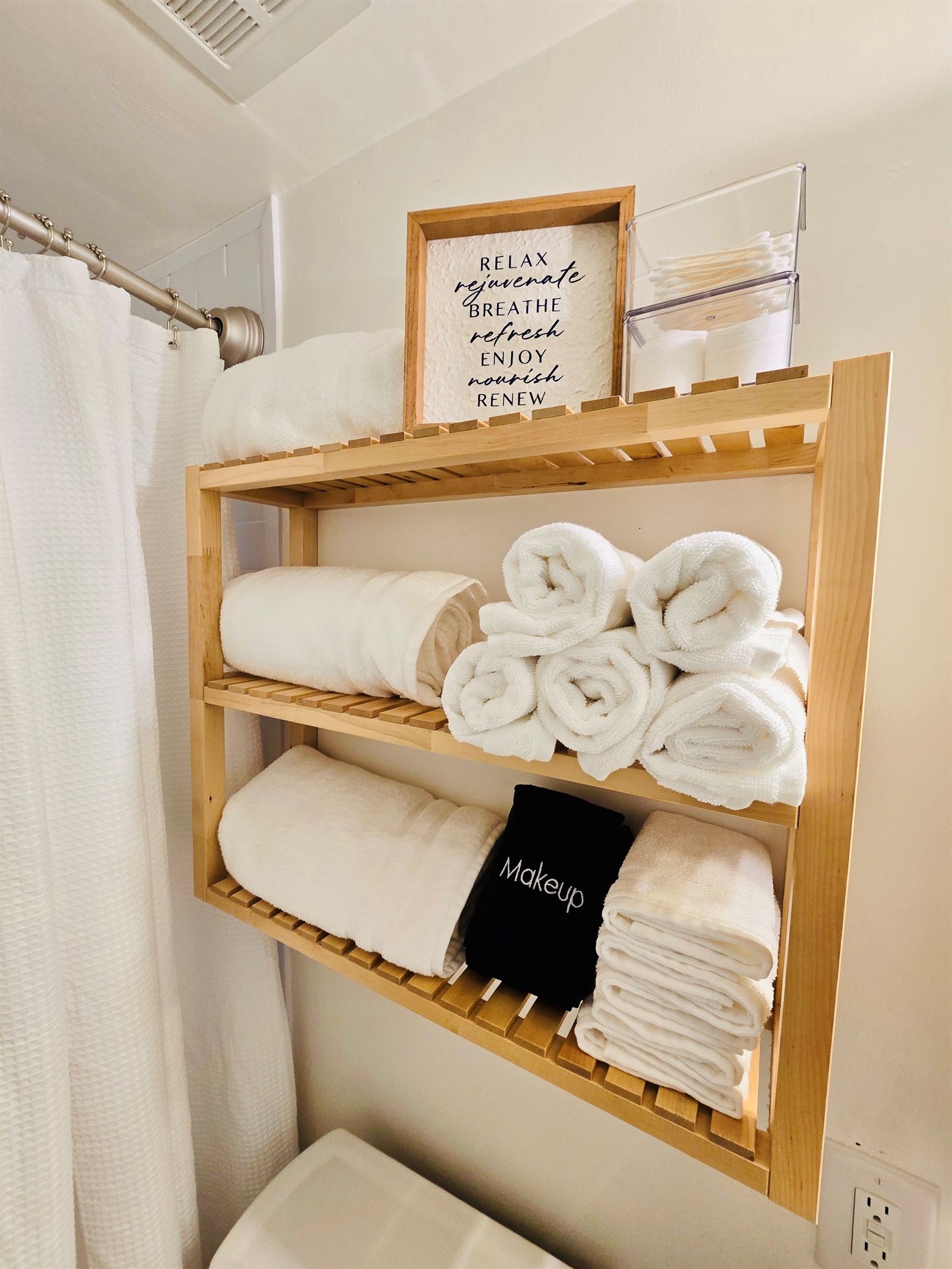 Spa vibes, stocked and ready—plush white towels and dedicated makeup cloths are rolled and waiting to pamper you in our crisp, clean bathroom retreat. Thoughtful touches, beautifully displayed.