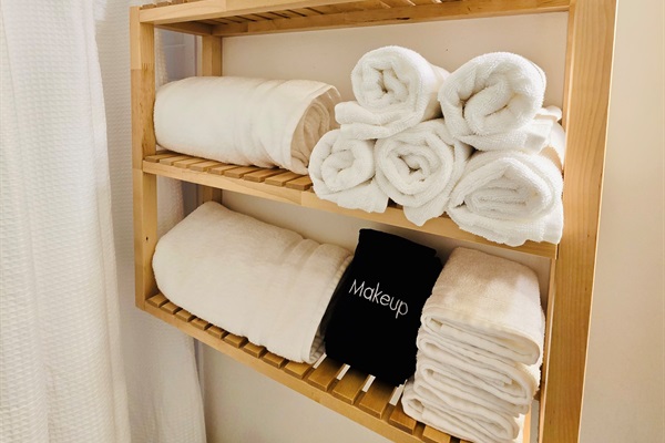 Spa vibes, stocked and ready—plush white towels and dedicated makeup cloths are rolled and waiting to pamper you in our crisp, clean bathroom retreat. Thoughtful touches, beautifully displayed.
