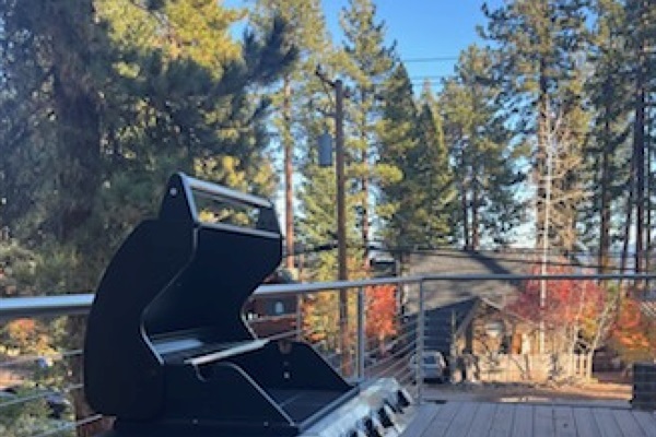 Outdoor gas BBQ grill on private deck, ideal for grilling and outdoor meals in a forest setting