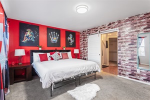 Master Bedroom: A serene retreat of comfort and style, featuring a luxurious king-sized bed, striking red accent walls, and captivating artwork that blends creativity with relaxation.