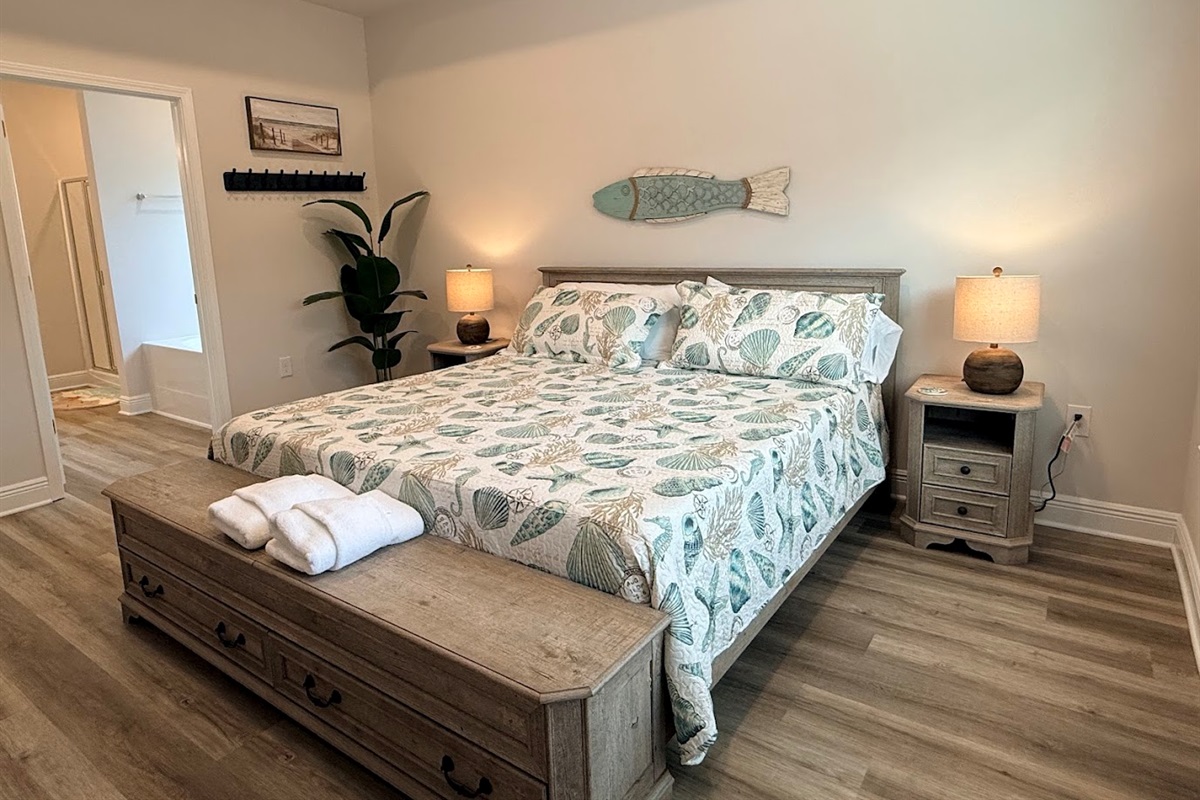 Serene primary suite with a king bed and calming coastal décor. Relaxing retreat with a comfortable king bed and smart TV.
