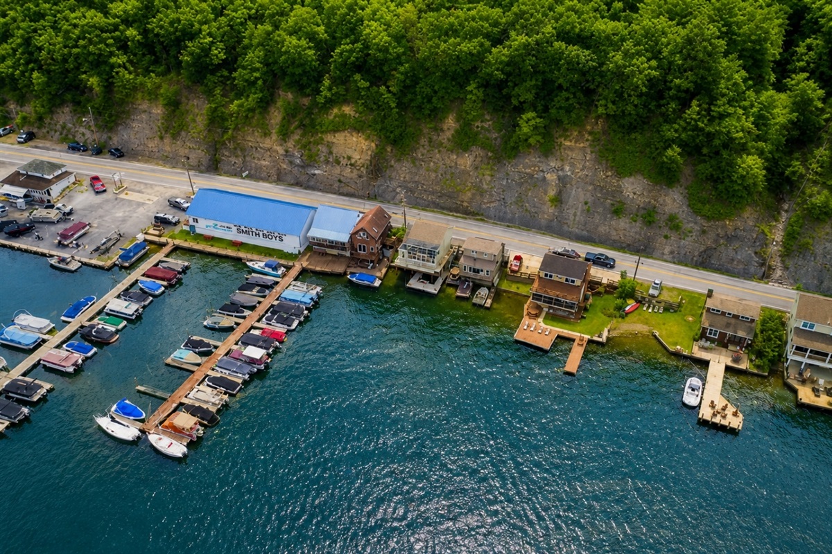 Nestled at the edge of a serene lake, this charming dock features a row of inviting, comfortable chairs, perfect for relaxing and enjoying the peaceful surroundings. The chairs, crafted from weather-resistant materials, are designed for comfort with 