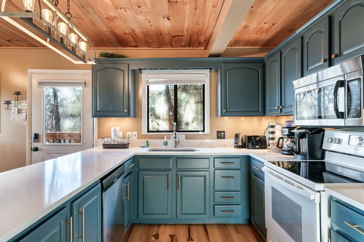 A recently renovated kitchen is stocked with silverware, plates, cookware, utensils, coffee makers, a toaster and more!