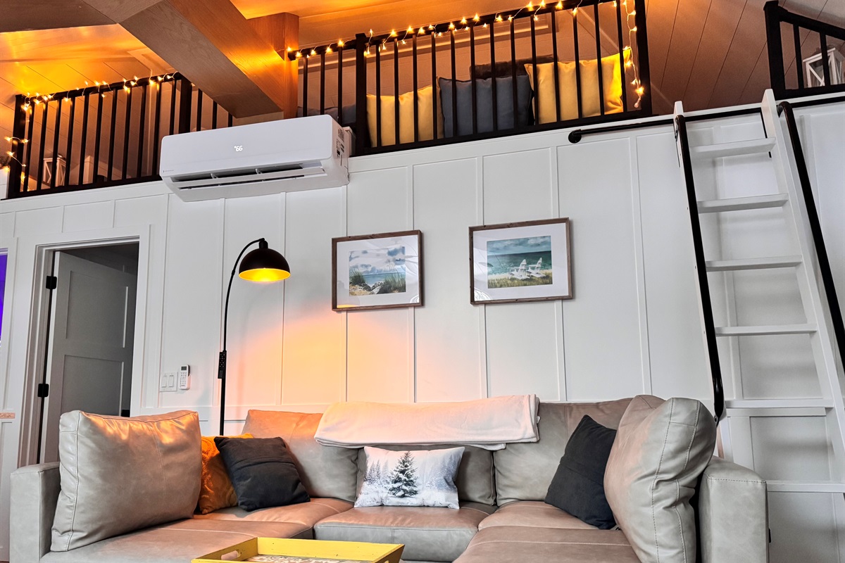 Sunrise Cottage  - Fun twinkle lights adorn the loft and the inviting living room with a stylish sofa and a variety of games, creating the perfect space for cozy nights, laughter, and memorable moments.
