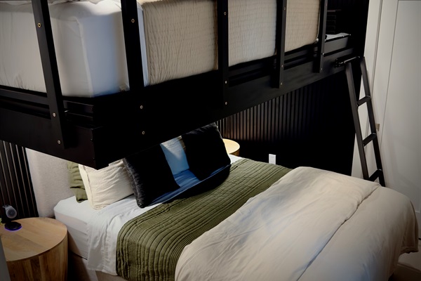 Acoustic wood and felt slat panels surround the bunk bed above and below. It is custom-made from 2 x 6 steel beams, and anchored directly to the walls - incredibly strong, quiet and a great place for kids to hide out and enjoy their own TV.