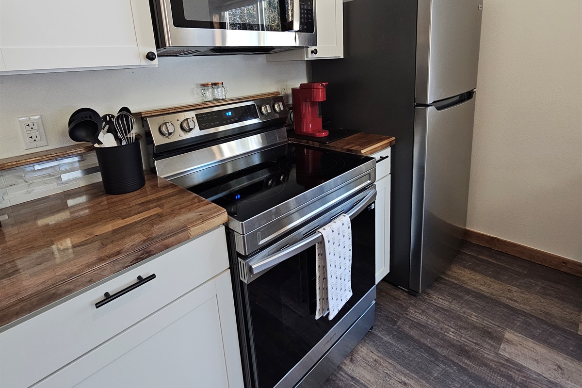 Kitchen includes an electric range, refrigerator, and Keurig.