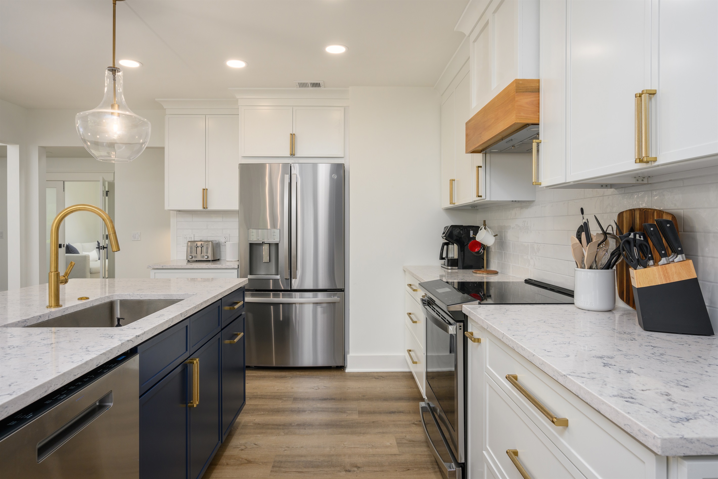 Fridge features indoor ice and water dispenser; stove is an electric induction cooktop