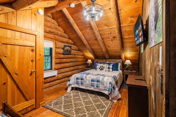 Cozy log cabin bedroom with rustic charm, soft lighting, and a comfy queen bed—perfect for a restful mountain retreat.