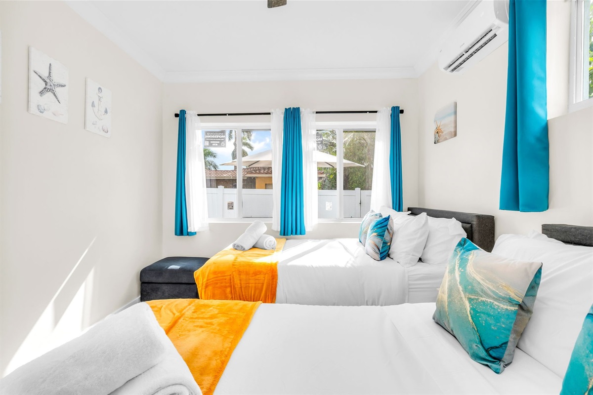 Relax in the sunny 4th bedroom—complete with two full-size beds, coastal décor, and a freshly updated ensuite bathroom.