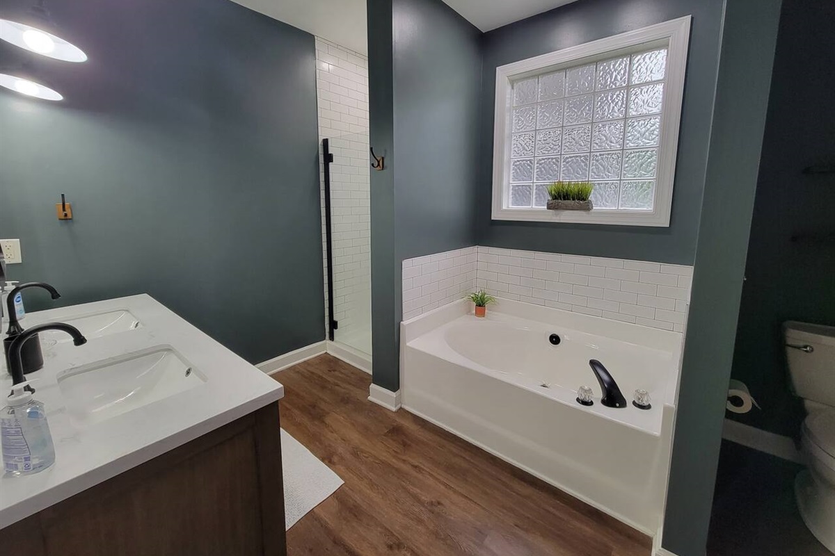 Master bathroom with tub, shower, and dual vanities