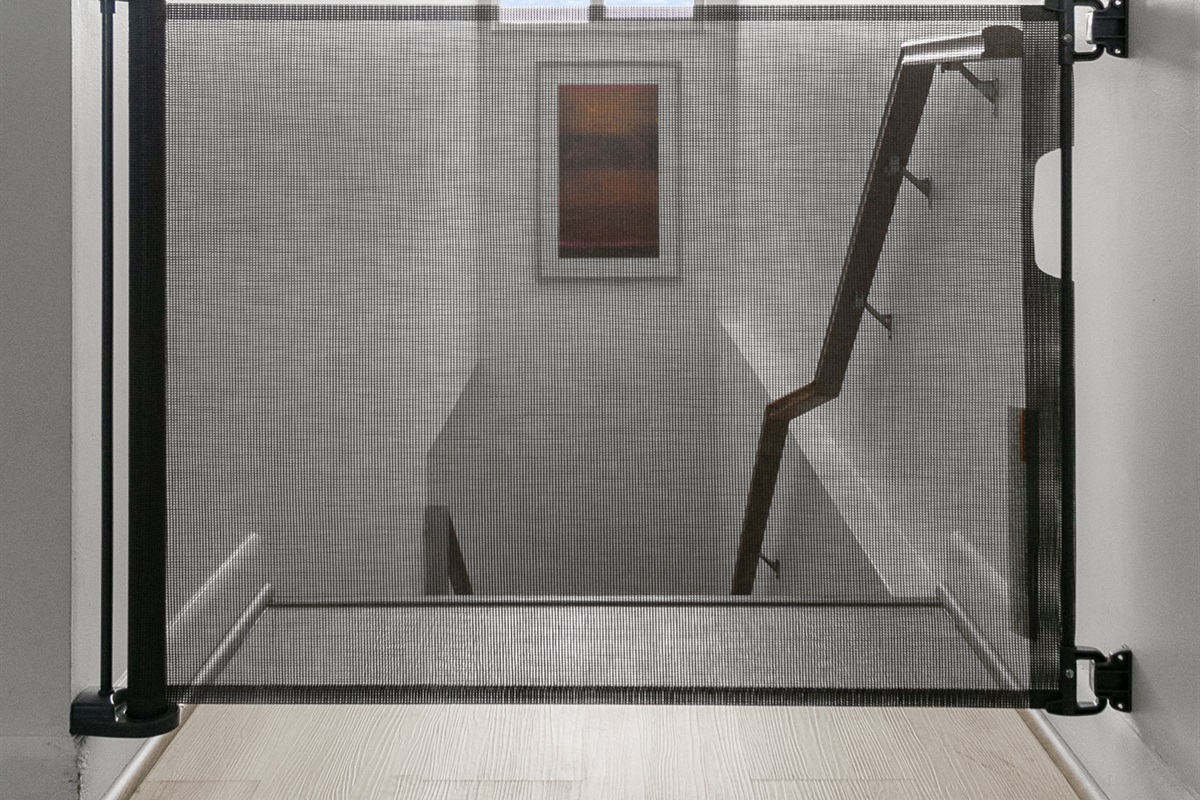 Retracting safety gate at top of stair landing