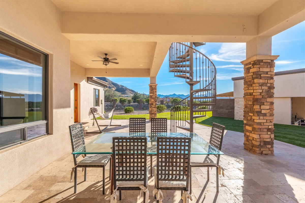 Spacious covered patio dining space connects seamlessly to the backyard and pool entertainment areas