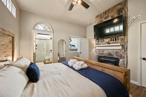 Bedroom 1 has a king bed, electric fireplace, and fabulous ensuite bathroom