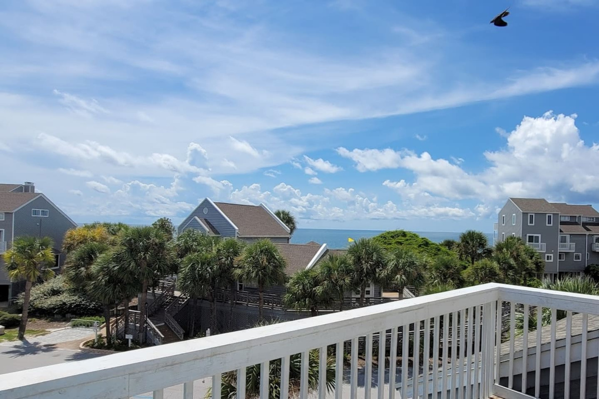 Step out here your first morning &mdash; Gulf through the palms, salt air, the whole week still ahead of you.