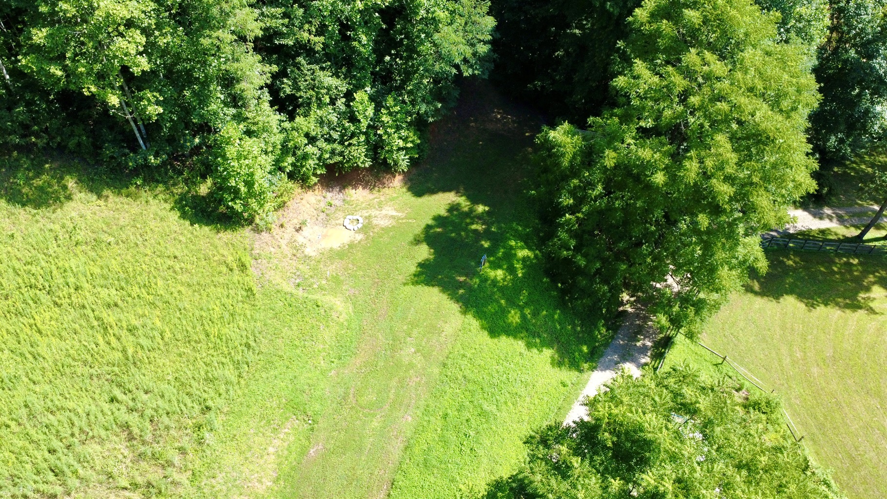 Grass RV site with fire ring, hookups, and extra tent space.
