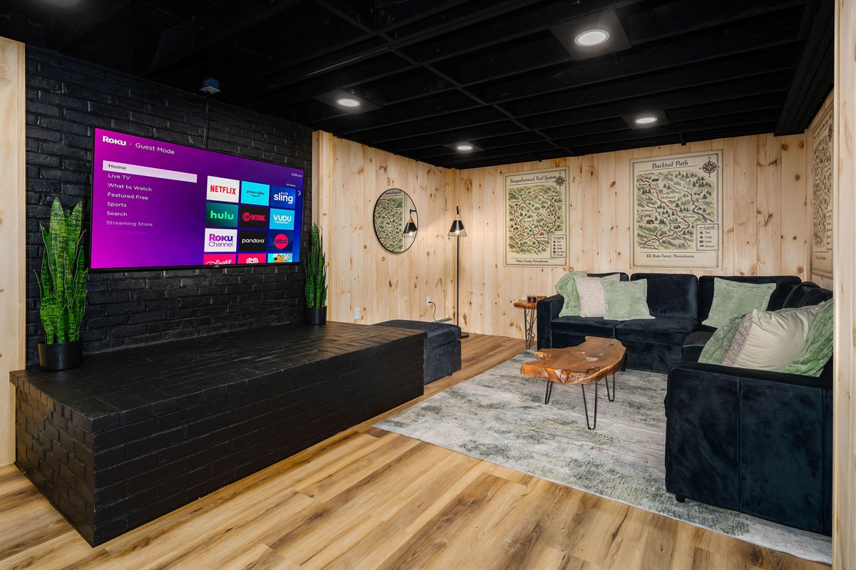 📺 A 65" TV and sectional that seats eight — the ultimate movie-and-game cave.