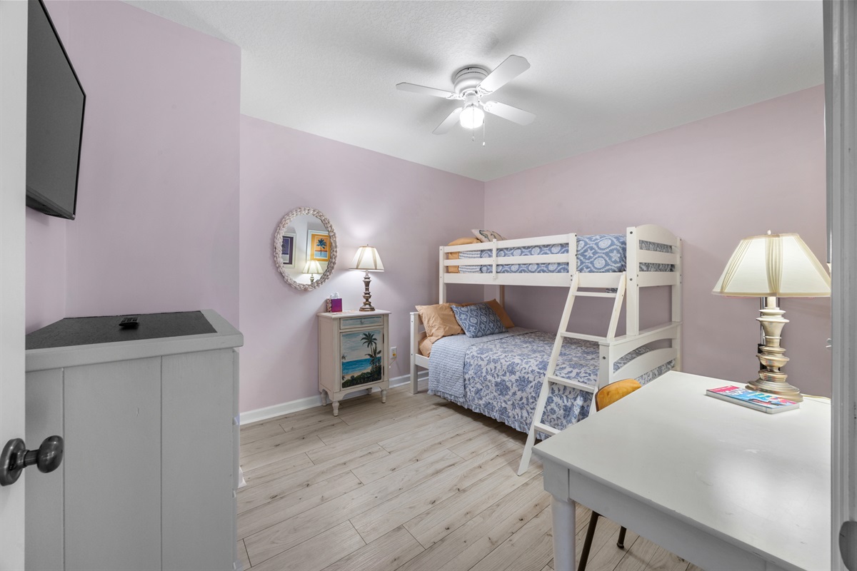 Charming bunk room with pastel tones, workspace, and coastal décor — perfect for kids or extra guests.