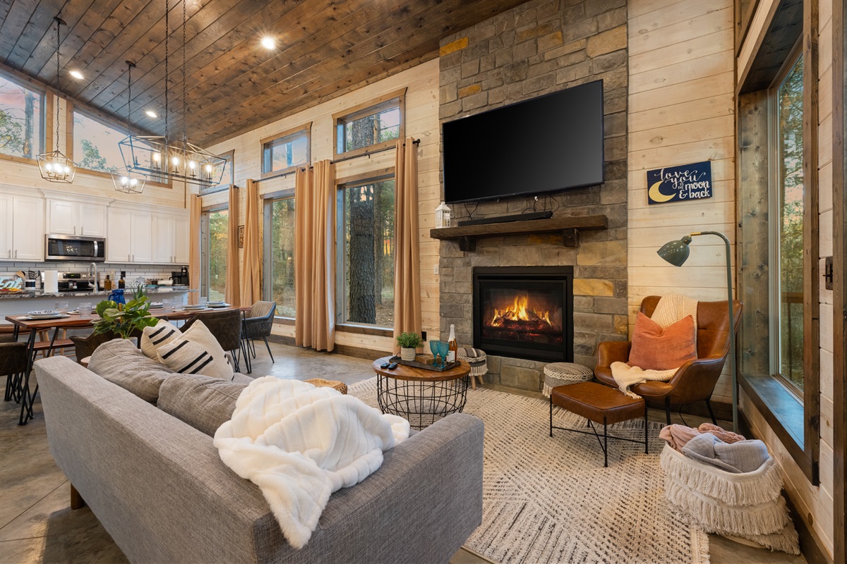 A warm hearth anchors the room with rustic stone and calm light. Curl up with a book, pour something warm, and let the evening slow to a comfortable hush.
