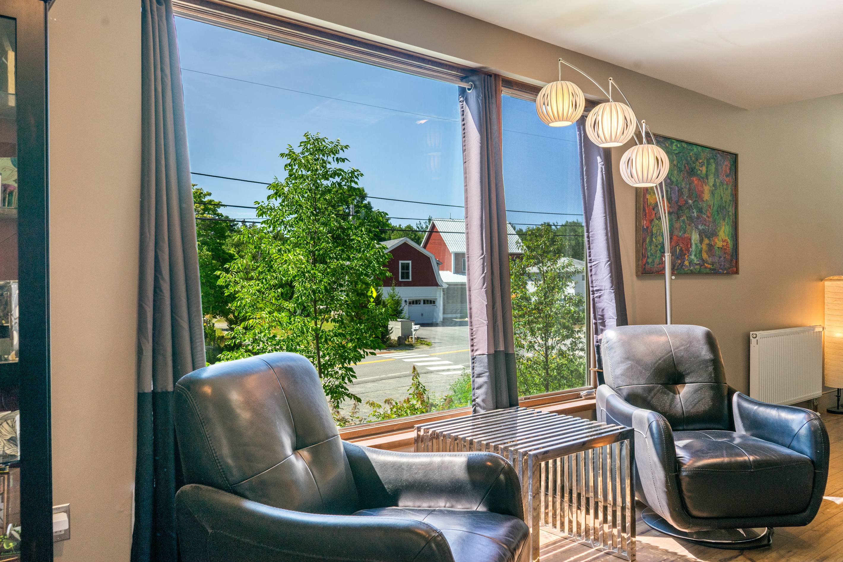 A second sun-filled sitting area on the main floor, featuring modern lounge seating and designer lighting. This quiet nook offers peaceful views of historic Otter Creek village, providing the perfect space for morning reading or private conversation.